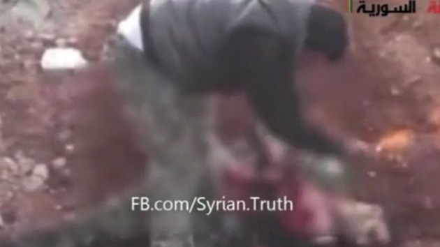 Un rebelde muerde el corazón extraído del pecho de un soldado sirio muerto