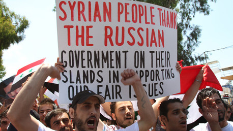 Manifestantes libaneses y sirios ondean banderas sirias y un cartel agradeciendo a Rusia por apoyar al presidente Bashar al Assad.