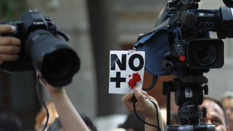 Un periodista muestra un cartel de 'No más sangre' durante una protesta contra el asesinato de un trabajador de prensa