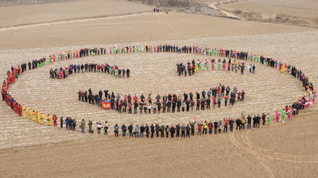 Los chinos forman una cara sonriente en un campo para celebrar el Año Nuevo 