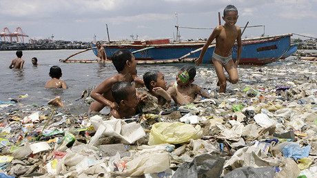 Los niños juegan mientras se bañan en la bahía de Manila