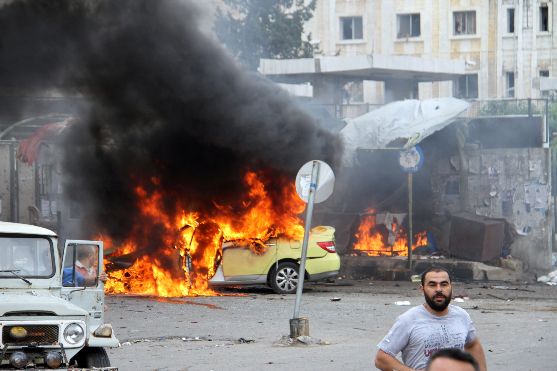 Varias personas examinan los daños que causaron unas explosiones en Tartús, Siria.