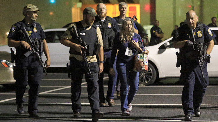 Un grupo de policías escolta a una mujer cerca del lugar del ataque de Dallas.
