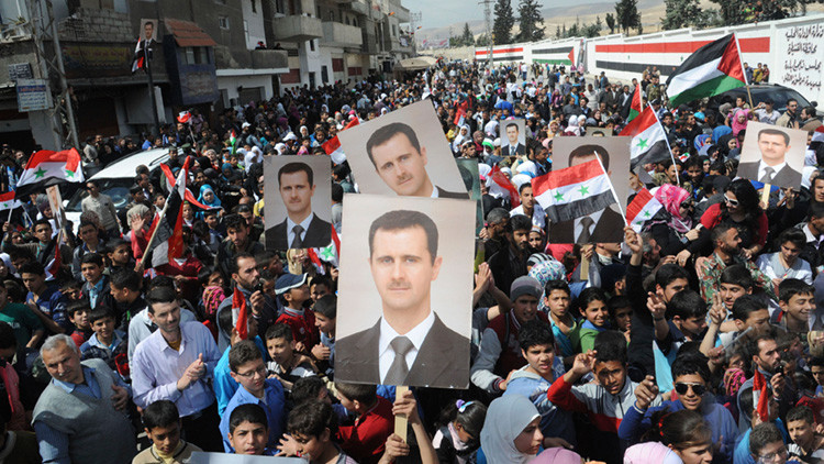 Ciudadanos sirios muestran su apoyo al presidente del país, Bashar al Assad y al Ejército sirio en la ciudad de Artouz, 19 de de marzo de 2014.