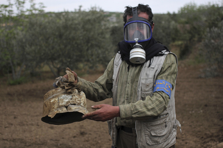 Un miembro de la Protección Civil siria sostiene un recipiente de gas cloro en el pueblo de Ibleen, Siria, 3 de mayo de 2015.