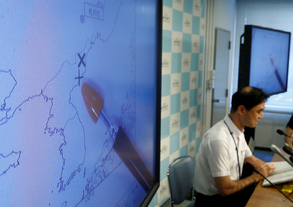 El director de la división de observaciones de terremotos y tsunamis de la Agencia Meteorológica de Japón, Gen Aoki, habla junto a pantallas que muestran el movimiento sísmico en Corea del Norte el 9 de septiembre de 2016.