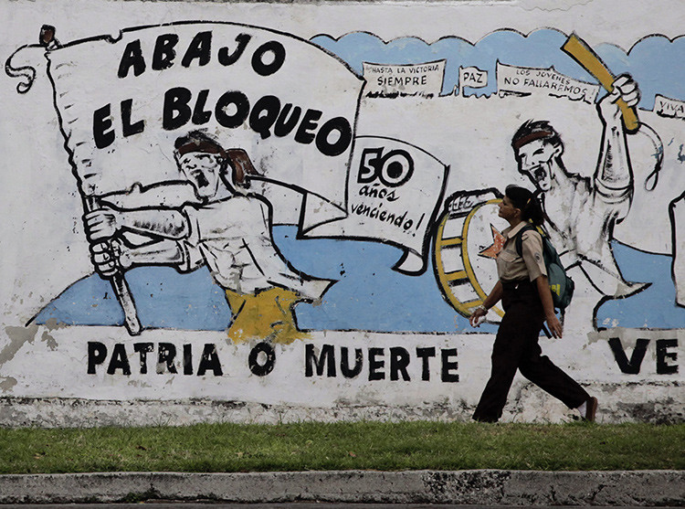 Una mujer camina en La Habana frente a un mural sobre el embargo económico de EE.UU. 26 de octubre de 2010.