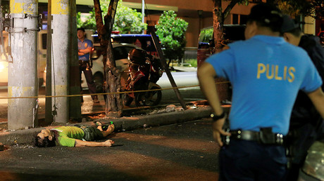 Agentes de la Policía Nacional de Filipinas cerca del cuerpo de un presunto traficante de drogas, que murió durante una operación policial en la ciudad de Malate.