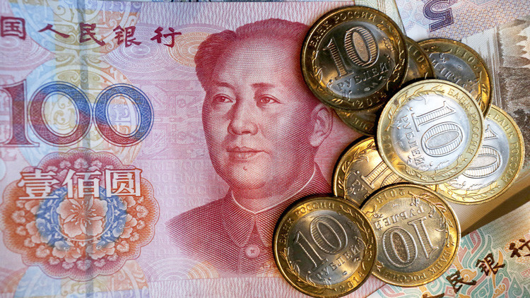 Un billete chino de 100 yuanes y monedas rusas de 10 rublos