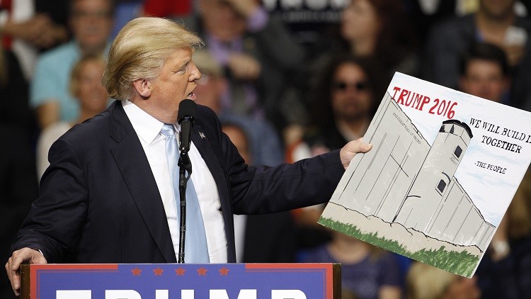 El aspirante republicano a la Casa Blanca, Donald Trump, sostiene un dibujo del muro que planea construir entre EE.UU. y México, el 10 de marzo de 2016.