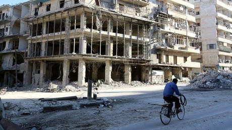 Un hombre monta en bicicleta junto a un edificio dañado en el barrio de Al Sukkari, Alepo, Siria, el 19 de octubre de 2016.