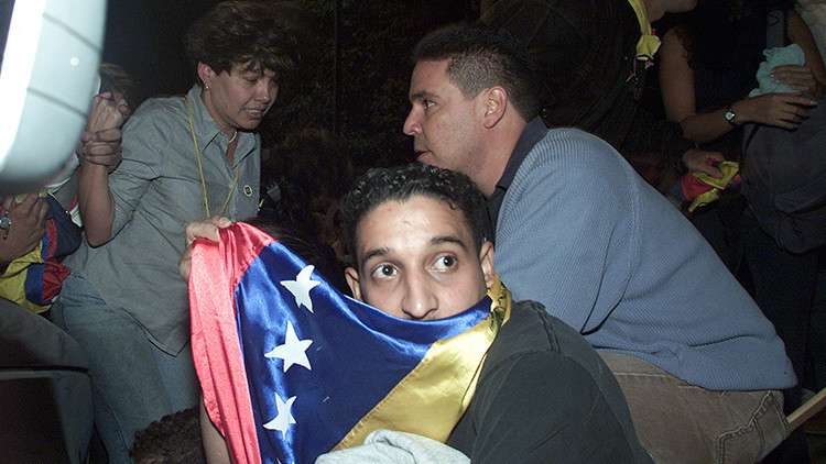 Manifestantes se esconden de los disparos de João de Gouveia, en Caracas el 6 de diciembre de 2002.
